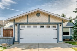 Garage exterior featuring a stucco finish with timber-style trim - 