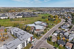 Expansive neighborhood featuring residential properties, mature trees, and a community building - 