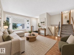 Hardwood-style flooring, expansive bay window, front entry door, staircase with wood railing, and recessed lighting - 