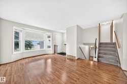 Bay window, wood-finish flooring, staircase with carpeted treads, and multiple levels - 