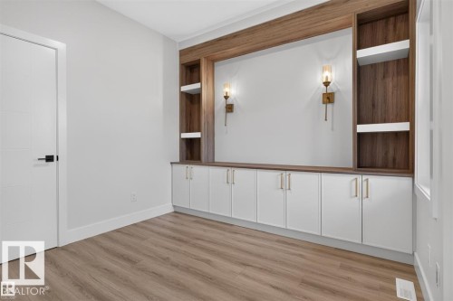 Built-in cabinetry with wood-finish accents, integrated shelving, and wall-mounted sconces - 101 Rosa Crescent, St. Albert, AB 