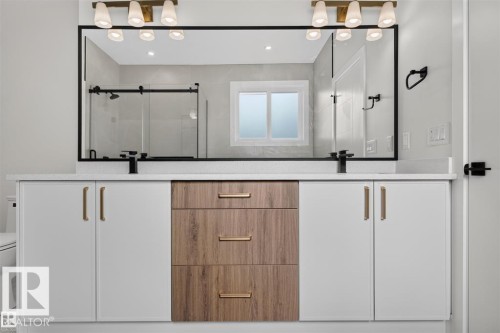 Dual vanity with white cabinetry, wood-finish drawers, and gold-tone hardware - 101 Rosa Crescent, St. Albert, AB 