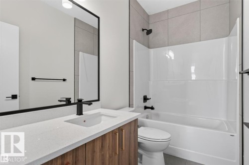 Wood-finish vanity with a white countertop and undermount sink - 101 Rosa Crescent, St. Albert, AB 