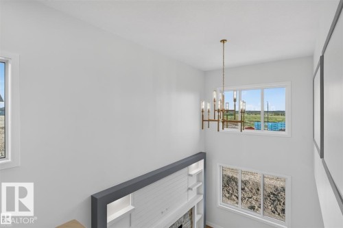 Vaulted ceiling, contemporary chandelier, multiple windows, built-in shelving, and a decorative fireplace - 101 Rosa Crescent, St. Albert, AB 