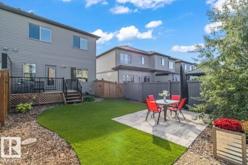 Spacious backyard featuring a low-maintenance artificial turf lawn, a stone paver patio, and a wood privacy fence - 75 Garneau Gate, Spruce Grove, AB 
