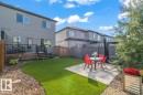 Spacious backyard featuring a low-maintenance artificial turf lawn, a stone paver patio, and a wood privacy fence - 75 Garneau Gate, Spruce Grove, AB 