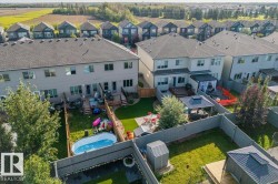 Manicured lawn, mature trees, privacy fencing, backyard patio, and surrounding residential area - 
