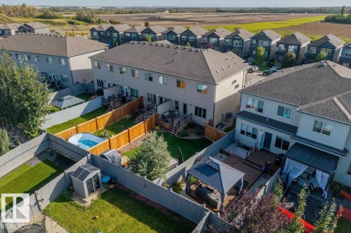 Private fenced backyard with a wood deck, mature landscaping, and an attached gazebo - 75 Garneau Gate, Spruce Grove, AB 
