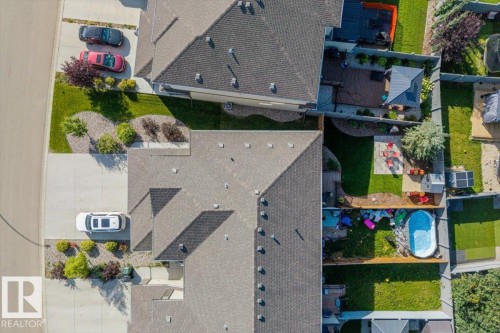 Expansive property featuring a paved driveway, landscaped front yard with shrubs, and a sloped roofline - 75 Garneau Gate, Spruce Grove, AB 