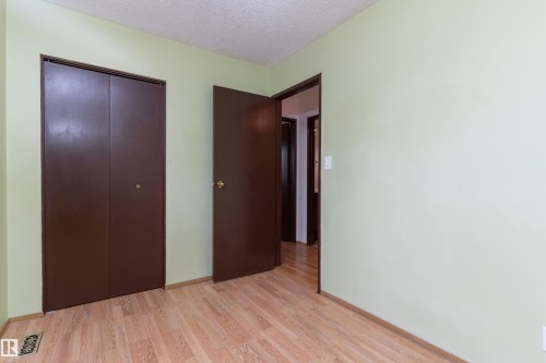 Light wood-finish flooring, bi-fold closet doors, and neutral wall tones - 18739 72 Avenue Nw, Edmonton, AB 