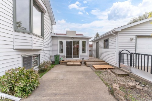 White horizontal siding on the exterior, featuring a sunroom with sliding glass doors and an attached garage - 18739 72 Avenue Nw, Edmonton, AB 