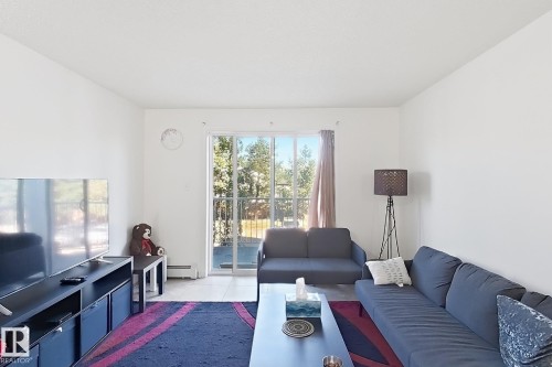White walls, a sliding glass door, and tiled flooring - #224 3425 19 St Nw, Edmonton, AB 