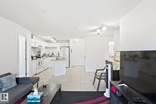 Open-concept living space with white walls and tile flooring - #224 3425 19 St Nw, Edmonton, AB 