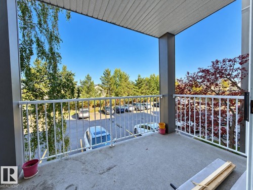 Private balcony with a concrete floor, white metal railings, and a solid overhead covering - #224 3425 19 St Nw, Edmonton, AB 