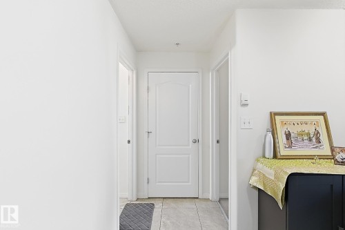 Hallway featuring a tiled floor and multiple interior doors - #224 3425 19 St Nw, Edmonton, AB 