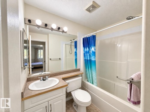Built-in vanity with an integrated sink, laminate countertop, and medicine cabinet - #224 3425 19 St Nw, Edmonton, AB 