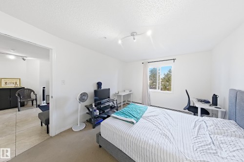 Bright room featuring a window with a green outdoor scenery, light-colored walls, and carpet flooring - #224 3425 19 St Nw, Edmonton, AB 