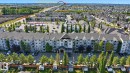 Multi-story building featuring multiple balconies, a structured roofline, and an integrated parking area - #224 3425 19 St Nw, Edmonton, AB 