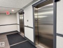 Two brushed stainless steel elevators with dark gray trim - #224 3425 19 St Nw, Edmonton, AB 