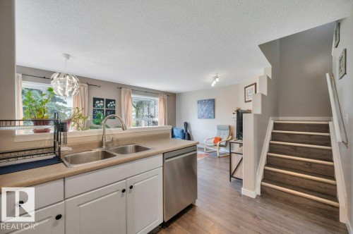 Kitchen with a dual basin sink, integrated dishwasher, and white cabinetry - 11448 169 Avenue Nw, Edmonton, AB 