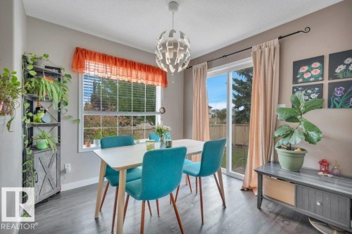 Vinyl plank flooring, contemporary chandelier, large window with blinds, and sliding glass door - 11448 169 Avenue Nw, Edmonton, AB 