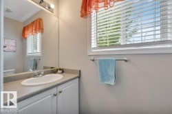 Handy 2-pc Bath on the main level. Vanity with an integrated sink, dual-door lower cabinetry, and a chrome faucet - 