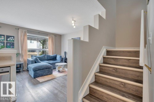 Vinyl plank flooring, staircase with vinyl plank treads, window with natural light, recessed ceiling lighting, and a neutral wall palette - 11448 169 Avenue Nw, Edmonton, AB 
