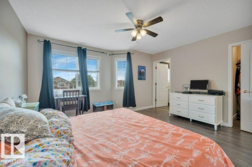Recessed windows with blinds, vinyl plank flooring, ceiling fan with integrated lighting, and white paneled doors - 11448 169 Avenue Nw, Edmonton, AB 