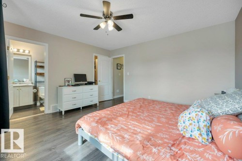 Primary Bedroom with 4-pc Ensuite and Walk-in Closet. Vinyl plank flooring, ceiling fan, and light-toned walls. - 11448 169 Avenue Nw, Edmonton, AB 