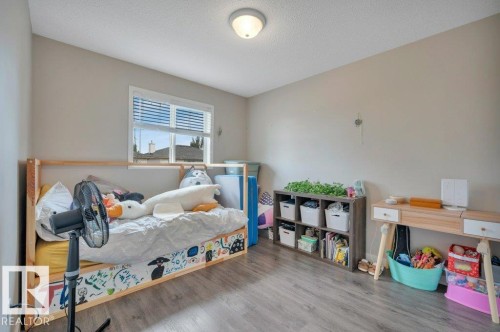 Room featuring a window with blinds, vinyl plank flooring, and a flush-mount ceiling light - 11448 169 Avenue Nw, Edmonton, AB 