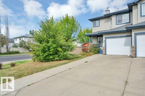 Light-toned siding exterior with dark trim accents, single attached garage, and a concrete driveway. Room for 3 vehicles.  One in the garage, 2 on the driveway (tandem) - 11448 169 Avenue Nw, Edmonton, AB 