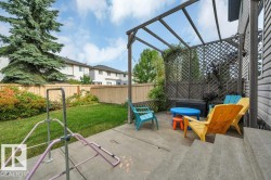 Concrete patio featuring a wood pergola and lattice privacy screen - 