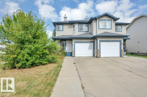 Two-story property featuring light-colored siding, contrasting blue trim, and single attached garage - 11448 169 Avenue Nw, Edmonton, AB 