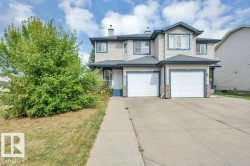 Two-story property featuring light-colored siding, contrasting blue trim, and single attached garage - 