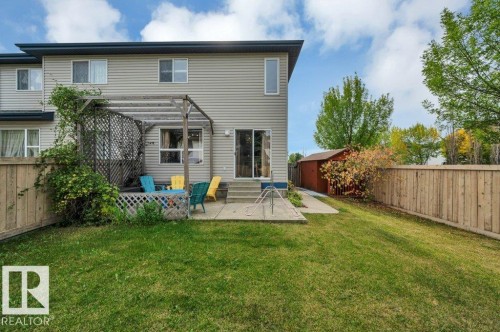 Fenced backyard with a concrete patio, wood pergola, and a storage shed - 11448 169 Avenue Nw, Edmonton, AB 