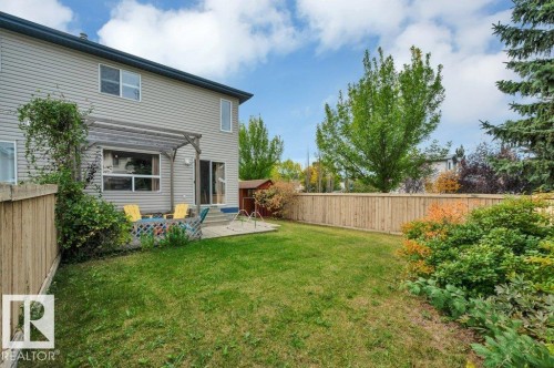 Expansive grassy yard with wood fencing, mature trees, and established shrubbery - 11448 169 Avenue Nw, Edmonton, AB 