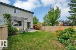 Expansive grassy yard with wood fencing, mature trees, and established shrubbery - 