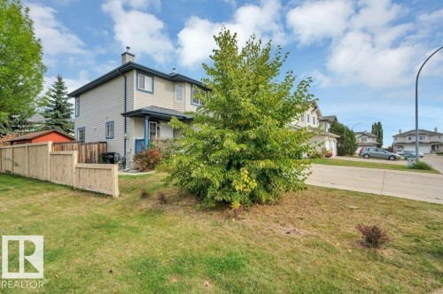 Siding exterior with contrasting trim, private fenced yard, mature landscaping, and a paved street - 11448 169 Avenue Nw, Edmonton, AB 