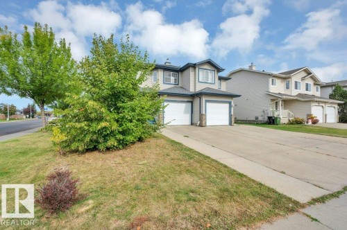 Two-story exterior with light-colored siding, single attached garage, and a concrete driveway - 11448 169 Avenue Nw, Edmonton, AB 