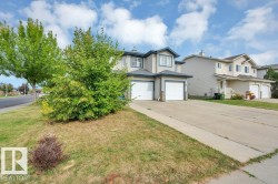 Two-story exterior with light-colored siding, single attached garage, and a concrete driveway - 