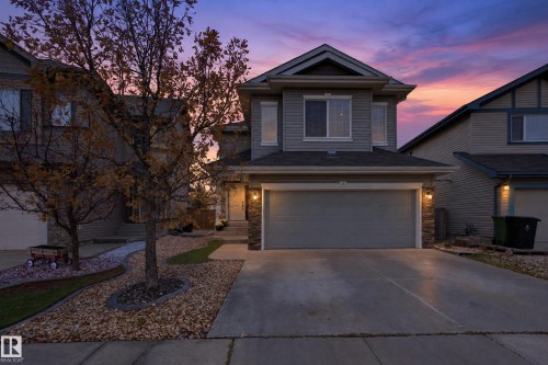 Two-story residence featuring horizontal siding, a stone veneer garage facade, a concrete driveway, and covered entryway - 7 Bremner, Fort Saskatchewan, AB 