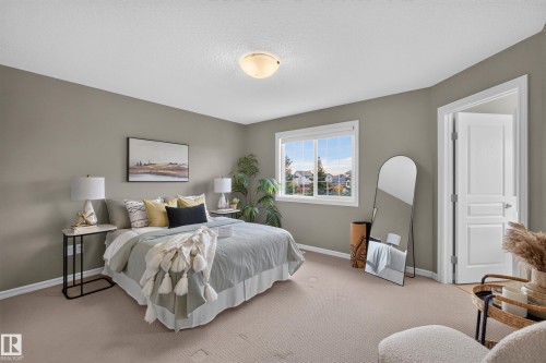Neutral-toned interior featuring wall-to-wall carpeting, sliding window with white trim, and a three-panel door with architectural casing - 7 Bremner, Fort Saskatchewan, AB 