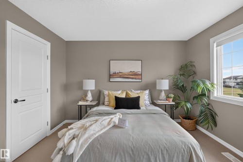Neutral-toned walls, carpeting, and a multi-pane window with white trim, featuring a classic two-panel interior door - 7 Bremner, Fort Saskatchewan, AB 