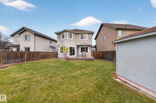 Rear exterior featuring a wood-plank deck, fenced backyard, and detached storage structure - 7 Bremner, Fort Saskatchewan, AB 