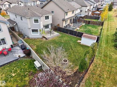 Fenced backyard featuring a wood deck, storage shed, circular fire pit, and privacy fencing - 7 Bremner, Fort Saskatchewan, AB 