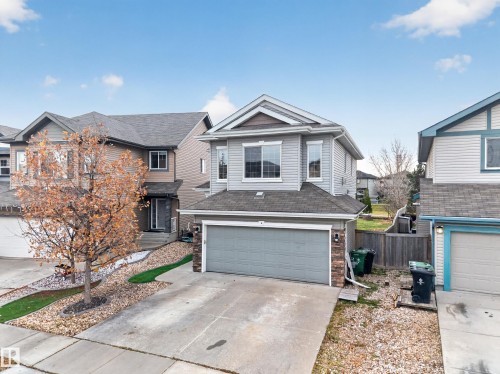 Two-story residence featuring light gray horizontal siding, a pitched roofline, stone veneer accents, and an attached two-car garage - 7 Bremner, Fort Saskatchewan, AB 