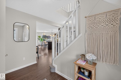 Staircase featuring white painted balusters and railings, wood-finish flooring, and neutral wall tones - 7 Bremner, Fort Saskatchewan, AB 