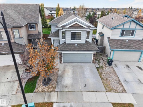 Two-story suburban home featuring a horizontal lap-siding exterior, an attached two-car garage, asphalt shingle roofing, and concrete driveway - 7 Bremner, Fort Saskatchewan, AB 