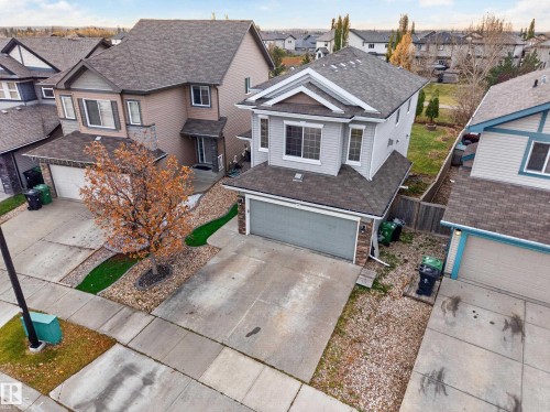 Two-story residence featuring light grey horizontal siding, a gabled roofline, stone veneer accents, and an attached two-car garage - 7 Bremner, Fort Saskatchewan, AB 