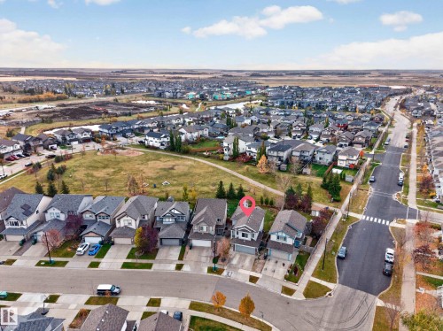 Aerial perspective of a detached residential property featuring a shingled roof, an attached two-car garage, and direct proximity to a large open green space - 7 Bremner, Fort Saskatchewan, AB 